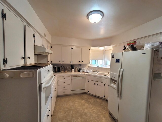 kitchen featuring white appliances, under cabinet range hood, tile countertops, and white cabinetry