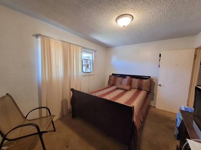 bedroom featuring carpet flooring and a textured ceiling