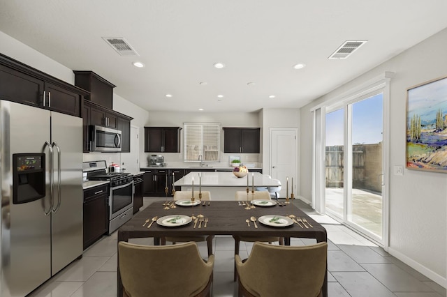 834 Amanecer Ave, Clovis, CA 93619 - kitchen featuring appliances with stainless steel finishes, light countertops, light tile patterned flooring, recessed lighting, and a center island