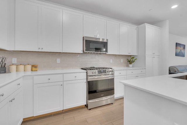 6569 E Lyell Ave, Fresno, CA 93727 - kitchen featuring appliances with stainless steel finishes, light countertops, decorative backsplash, light wood-type flooring, and white cabinets