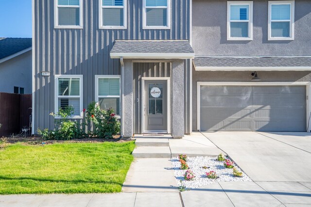 6569 E Lyell Ave, Fresno, CA 93727 - view of front of property featuring a garage, board and batten siding, and concrete driveway