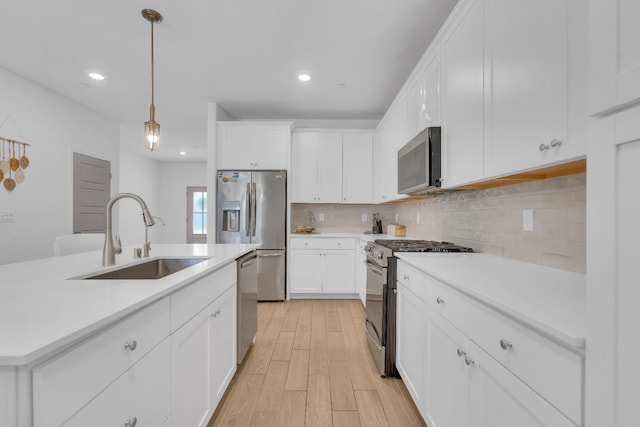 6569 E Lyell Ave, Fresno, CA 93727 - kitchen with appliances with stainless steel finishes, light wood finished floors, tasteful backsplash, light countertops, and recessed lighting