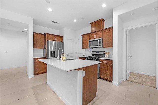 6105 W Richert Ave, Fresno, CA 93723 - kitchen with appliances with stainless steel finishes, a center island with sink, light countertops, recessed lighting, and brown cabinetry