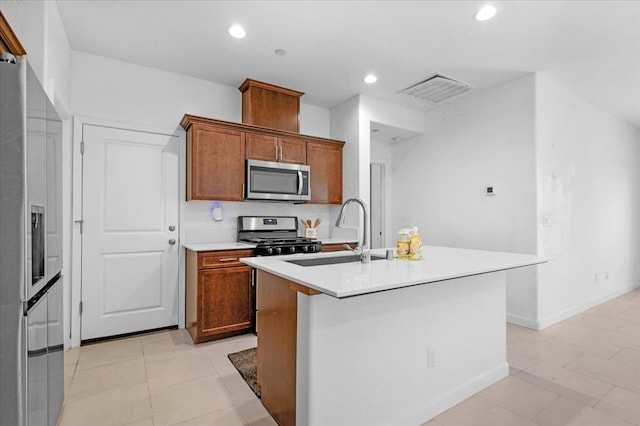 6105 W Richert Ave, Fresno, CA 93723 - kitchen with appliances with stainless steel finishes, brown cabinets, light countertops, an island with sink, and recessed lighting