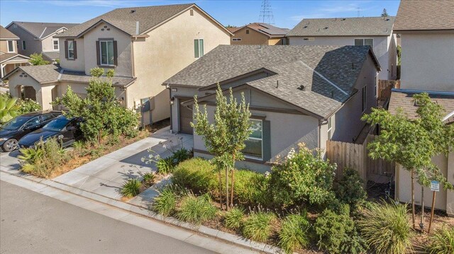 6105 W Richert Ave, Fresno, CA 93723 - view of front of house with stucco siding, a shingled roof, and a residential view