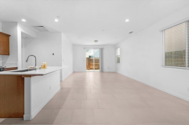 6105 W Richert Ave, Fresno, CA 93723 - kitchen featuring light countertops, recessed lighting, open floor plan, and brown cabinetry