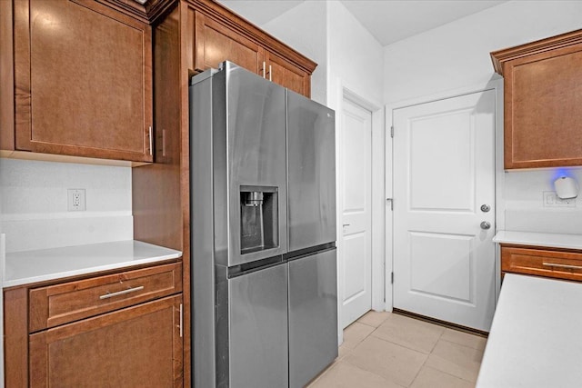6105 W Richert Ave, Fresno, CA 93723 - kitchen with stainless steel fridge with ice dispenser, light countertops, brown cabinetry, and light tile patterned floors