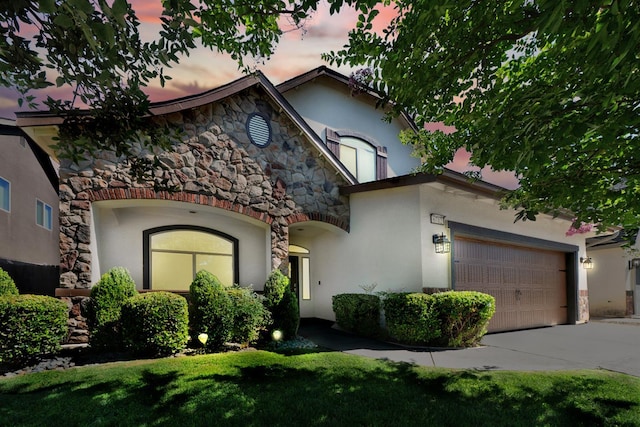 6712 W Lucas Dr, Fresno, CA 93722 - view of front facade featuring stone siding, stucco siding, concrete driveway, a garage, and a front lawn