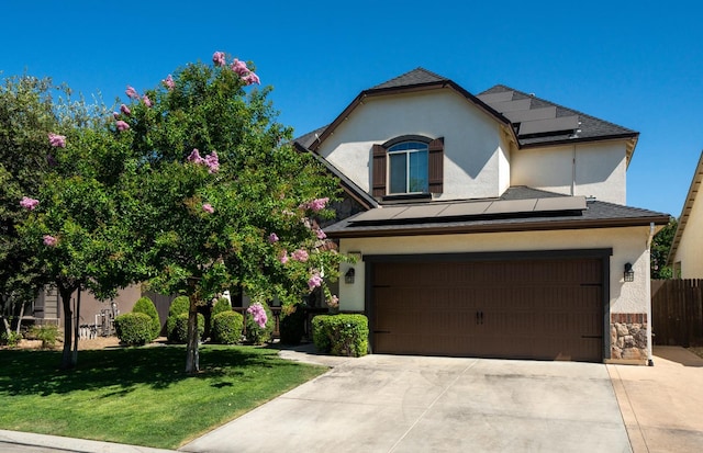 6712 W Lucas Dr, Fresno, CA 93722 - view of front of property featuring roof mounted solar panels, stucco siding, driveway, a front yard, and a garage