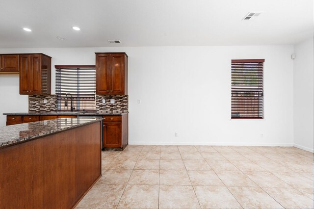 5227 E Florence Ave, Fresno, CA 93727 - kitchen with backsplash, recessed lighting, dark stone counters, and light tile patterned floors