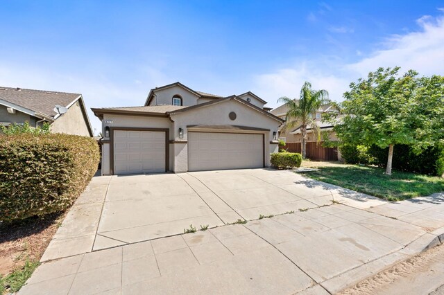5227 E Florence Ave, Fresno, CA 93727 - view of front of house featuring a garage, stucco siding, and driveway