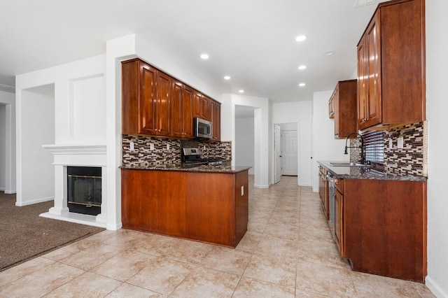 5227 E Florence Ave, Fresno, CA 93727 - kitchen with appliances with stainless steel finishes, tasteful backsplash, dark stone counters, recessed lighting, and light tile patterned flooring