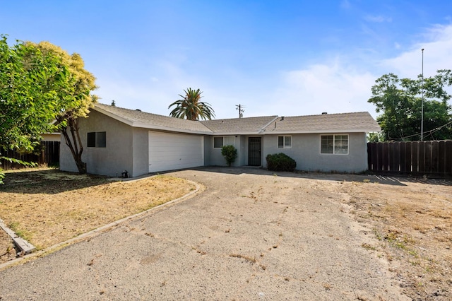 1428 N Knoll Ave, Fresno, CA 93722 - ranch-style home featuring stucco siding, a garage, and driveway