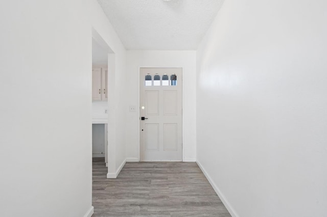 1428 N Knoll Ave, Fresno, CA 93722 - doorway to outside featuring light wood finished floors and a textured ceiling