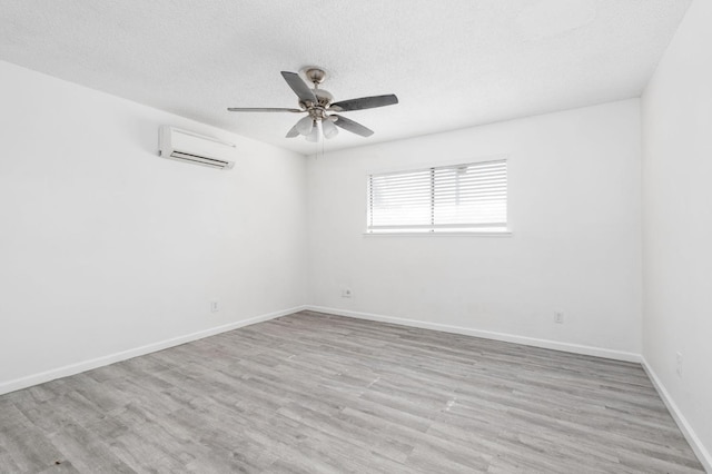 1428 N Knoll Ave, Fresno, CA 93722 - empty room featuring a wall mounted air conditioner, a textured ceiling, a ceiling fan, and light wood-style floors