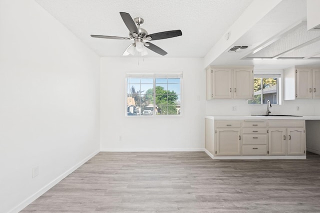 1428 N Knoll Ave, Fresno, CA 93722 - kitchen featuring light wood finished floors, light countertops, a ceiling fan, and a textured ceiling