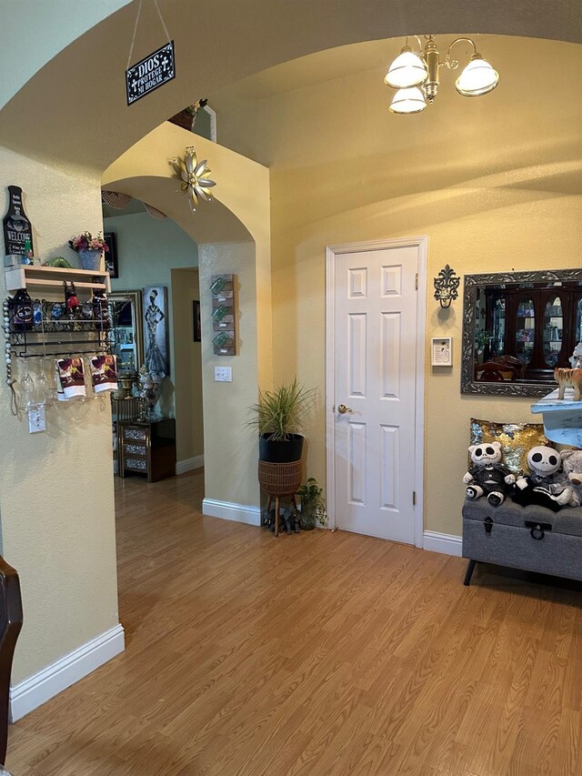 6675 N Lola Ave, Fresno, CA 93722 - entrance foyer with arched walkways, a chandelier, and wood finished floors