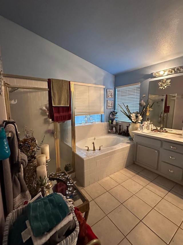 6675 N Lola Ave, Fresno, CA 93722 - full bathroom with lofted ceiling, vanity, a bath, tile patterned flooring, and a stall shower