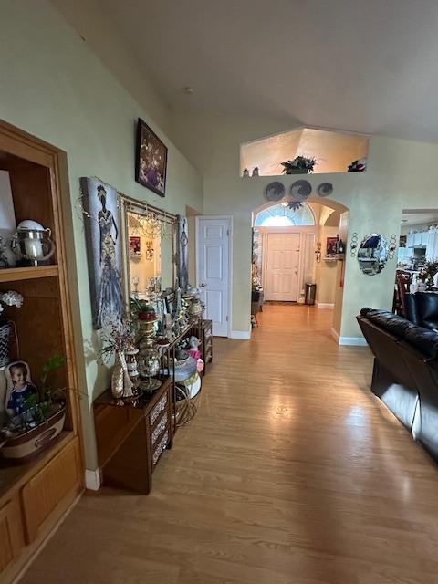 6675 N Lola Ave, Fresno, CA 93722 - hallway with arched walkways, wood finished floors, and a high ceiling