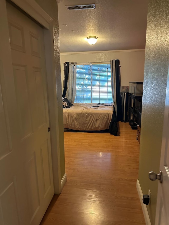 6675 N Lola Ave, Fresno, CA 93722 - hallway with light wood-style flooring and a textured ceiling