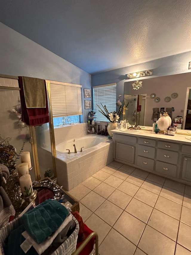 6675 N Lola Ave, Fresno, CA 93722 - full bathroom with tile patterned floors, a garden tub, double vanity, lofted ceiling, and a textured ceiling