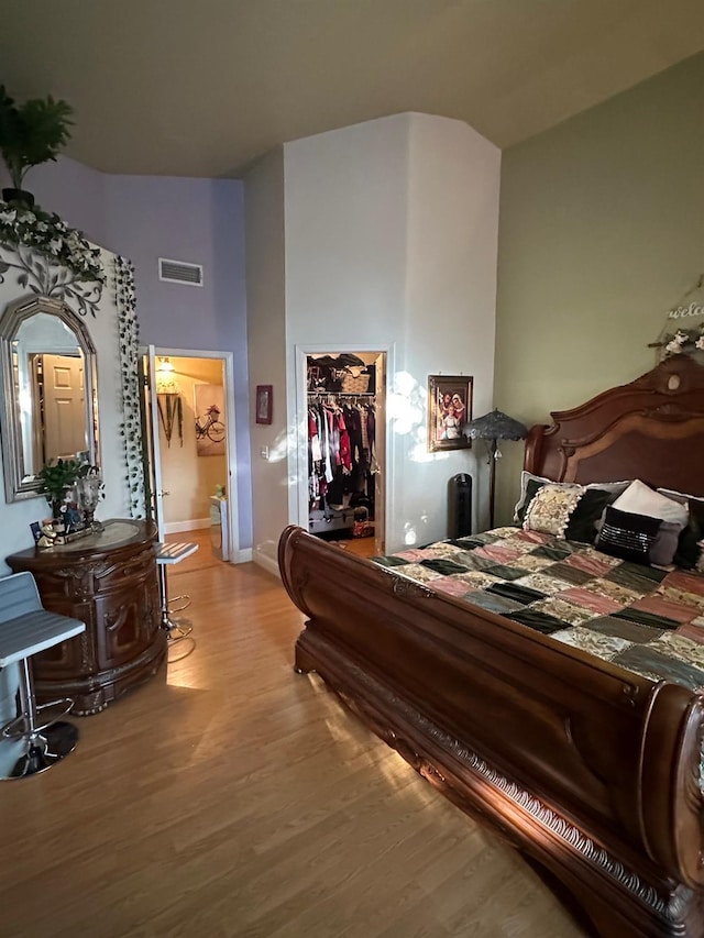 6675 N Lola Ave, Fresno, CA 93722 - bedroom featuring light wood finished floors, a walk in closet, a closet, and a towering ceiling