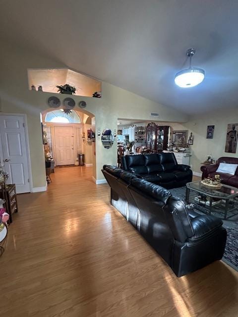 6675 N Lola Ave, Fresno, CA 93722 - living area featuring arched walkways, wood finished floors, and vaulted ceiling