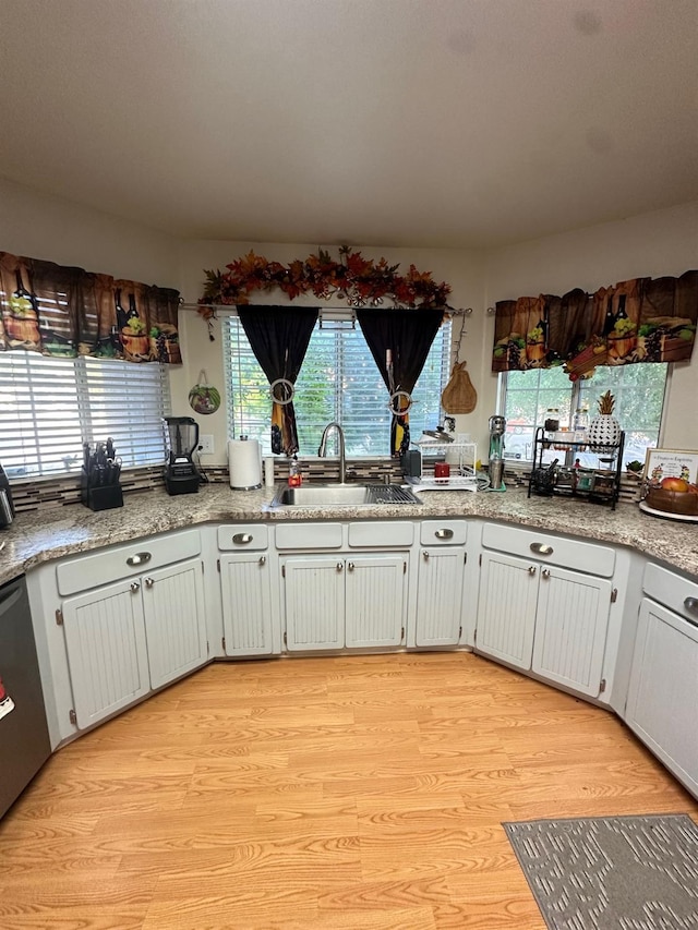 6675 N Lola Ave, Fresno, CA 93722 - kitchen with light wood finished floors, dishwasher, and light countertops