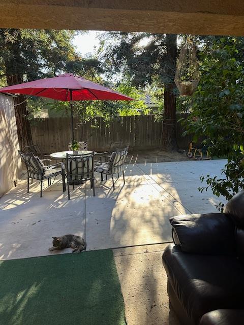 6675 N Lola Ave, Fresno, CA 93722 - fenced backyard featuring outdoor dining space and a patio area