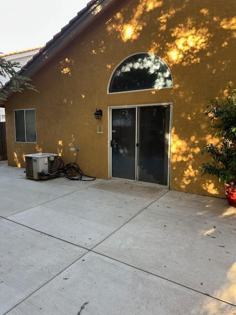 6675 N Lola Ave, Fresno, CA 93722 - rear view of property featuring stucco siding and a patio area