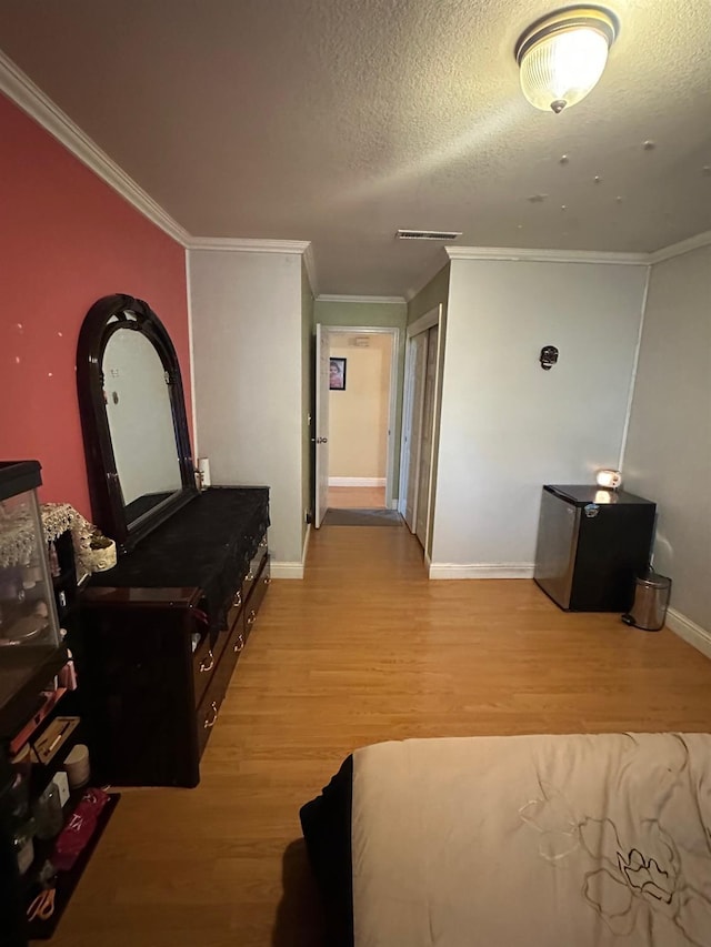 6675 N Lola Ave, Fresno, CA 93722 - living room with light wood-type flooring, crown molding, and a textured ceiling