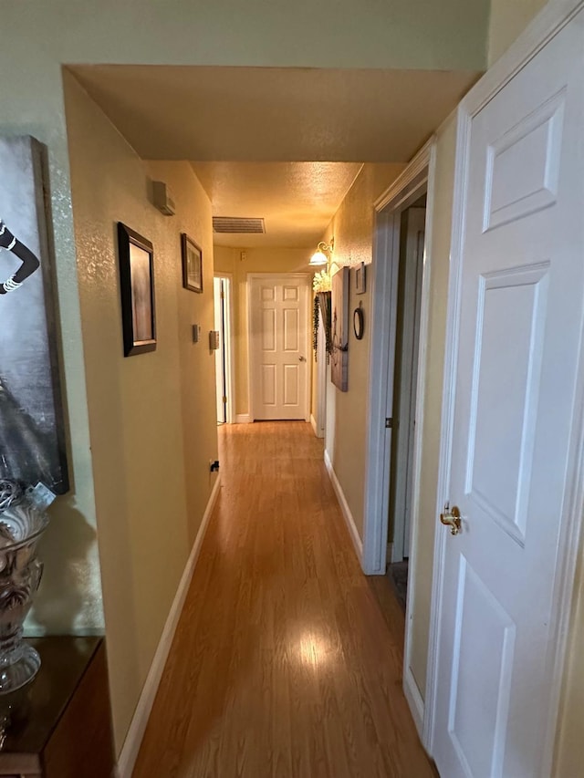 6675 N Lola Ave, Fresno, CA 93722 - corridor with light wood-style flooring and baseboards