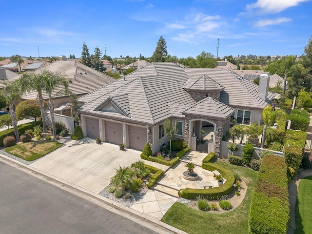 1568 E Sterling Hill Way, Fresno, CA 93730 - view of front facade with a tile roof, a garage, a chimney, driveway, and stone siding