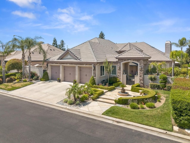 1568 E Sterling Hill Way, Fresno, CA 93730 - view of front of house with an attached garage, driveway, a tile roof, and stone siding