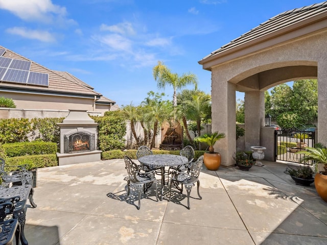 1568 E Sterling Hill Way, Fresno, CA 93730 - view of patio featuring a warm lit fireplace and outdoor dining space