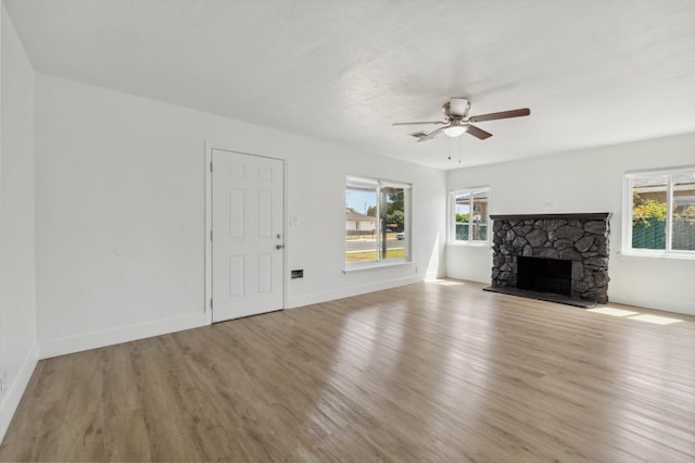 4752 E Kerckhoff Ave, Fresno, CA 93702 - unfurnished living room featuring a ceiling fan, wood finished floors, plenty of natural light, and a fireplace