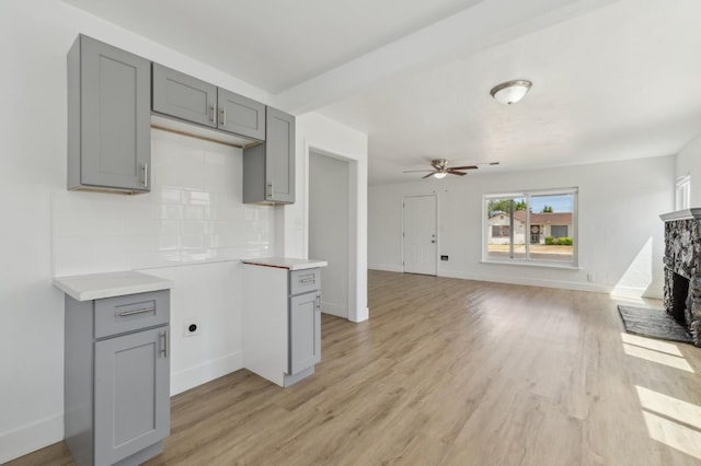 4752 E Kerckhoff Ave, Fresno, CA 93702 - kitchen featuring gray cabinetry, backsplash, light wood-style flooring, and light countertops