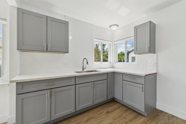 4752 E Kerckhoff Ave, Fresno, CA 93702 - kitchen featuring gray cabinets, decorative backsplash, light wood finished floors, and light countertops