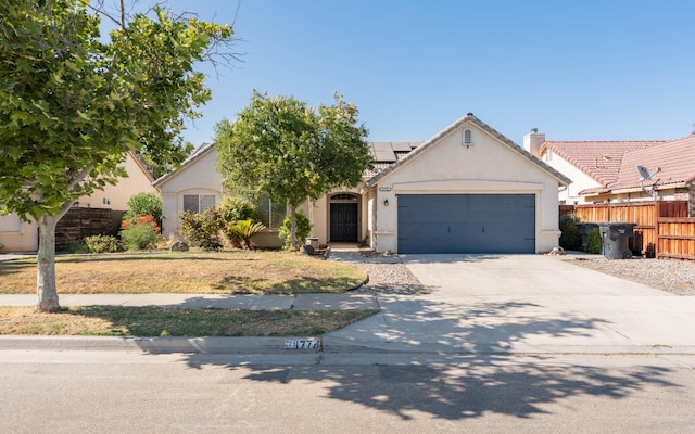 1774 Castle Way, Lemoore, CA 93245 - view of front of home with stucco siding, roof mounted solar panels, a garage, driveway, and a tiled roof
