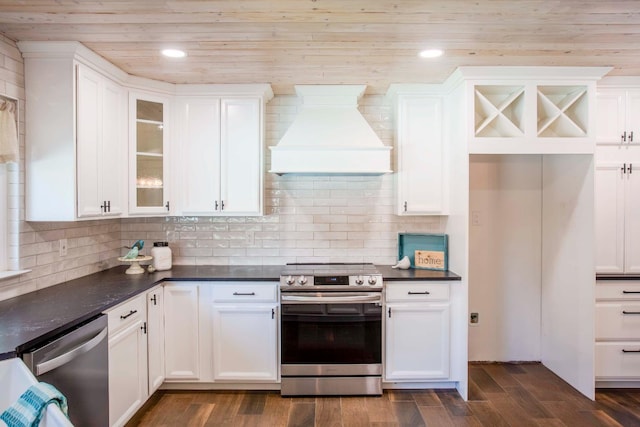 2540 Burgan Ave, Clovis, CA 93611 - kitchen with stainless steel appliances, custom exhaust hood, dark countertops, white cabinetry, and glass insert cabinets
