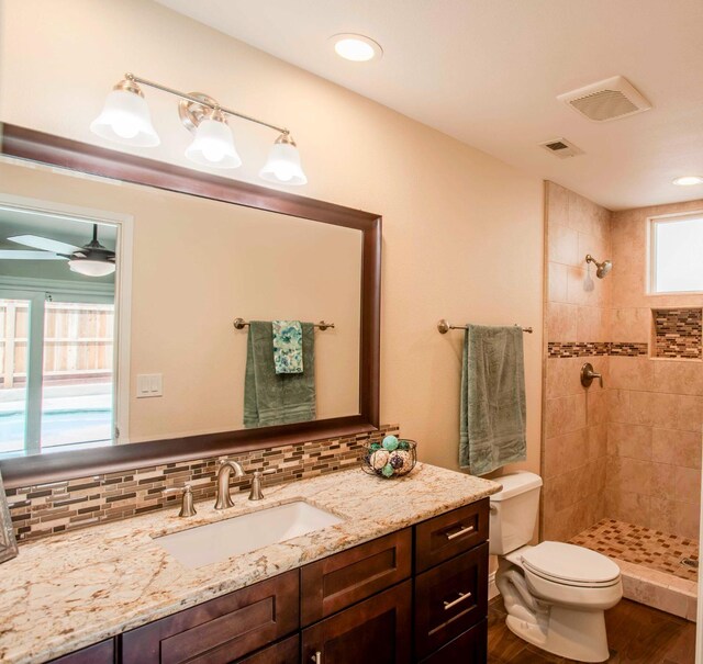2540 Burgan Ave, Clovis, CA 93611 - bathroom featuring vanity, a tile shower, tasteful backsplash, wood finished floors, and recessed lighting