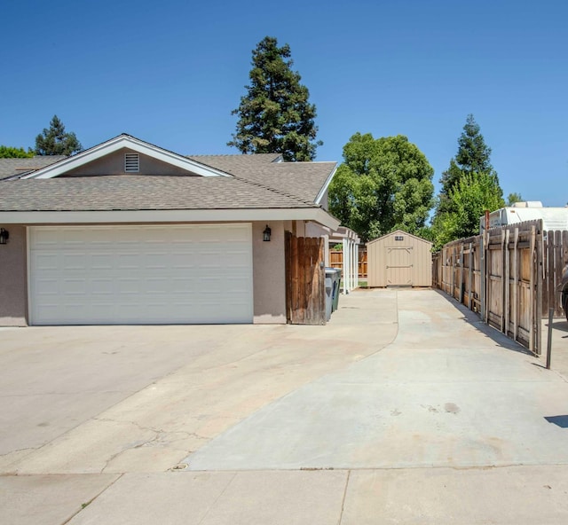 2540 Burgan Ave, Clovis, CA 93611 - view of home's exterior featuring stucco siding, a shed, concrete driveway, roof with shingles, and a garage