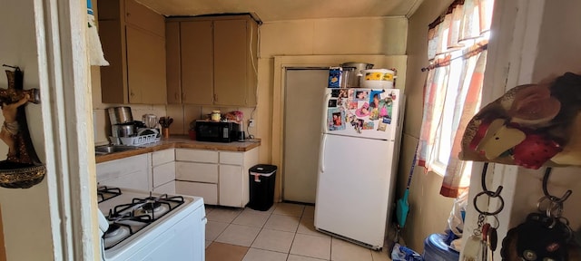 10691 Jones St, Riverdale, CA 93656 - kitchen with white appliances, light tile patterned flooring, and tile counters