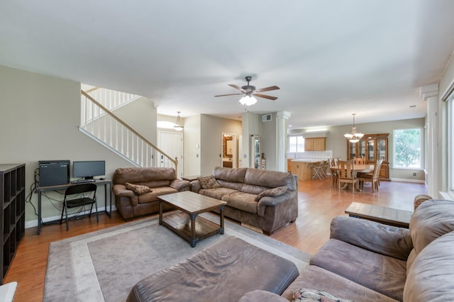 7718 N Constance Ave, Fresno, CA 93722 - living room with stairs, light wood finished floors, a chandelier, and ceiling fan