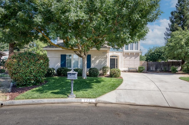 7718 N Constance Ave, Fresno, CA 93722 - view of property hidden behind natural elements featuring stucco siding and concrete driveway