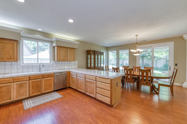 7718 N Constance Ave, Fresno, CA 93722 - kitchen with dishwasher, light wood finished floors, a peninsula, a chandelier, and backsplash