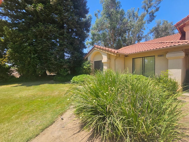 36883 Cloverleaf Ave, Madera, CA 93636 - view of side of home with a tile roof, stucco siding, and a yard