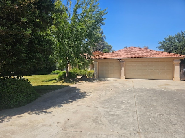 36883 Cloverleaf Ave, Madera, CA 93636 - view of front of property with a tiled roof, stucco siding, driveway, a garage, and a front yard