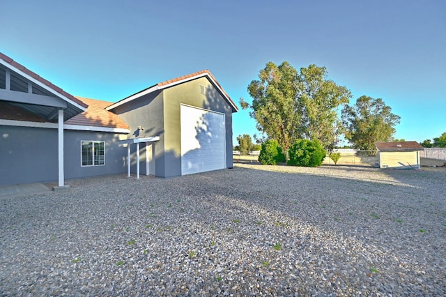 8037 E Morab Ave, Clovis, CA 93619 - rear view of property with stucco siding, driveway, an outbuilding, and a tile roof