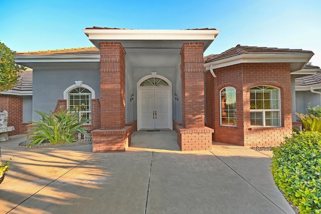 8037 E Morab Ave, Clovis, CA 93619 - view of exterior entry with brick siding, a tile roof, and stucco siding